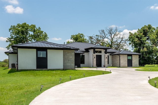 prairie-style home featuring central AC and a front lawn