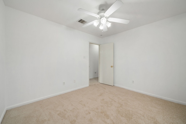 spare room featuring light colored carpet and ceiling fan