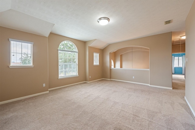 carpeted spare room with a textured ceiling