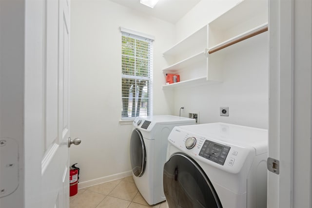 washroom with light tile patterned floors and washer and clothes dryer