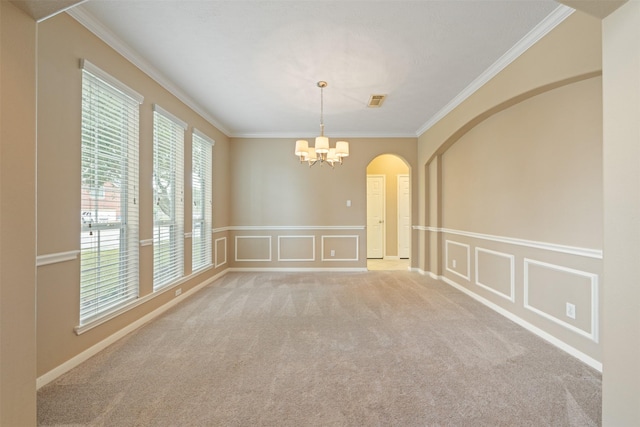 spare room with light carpet, crown molding, and a chandelier