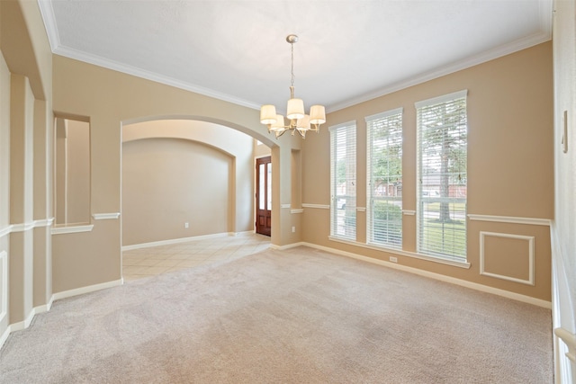 carpeted empty room featuring a notable chandelier and ornamental molding