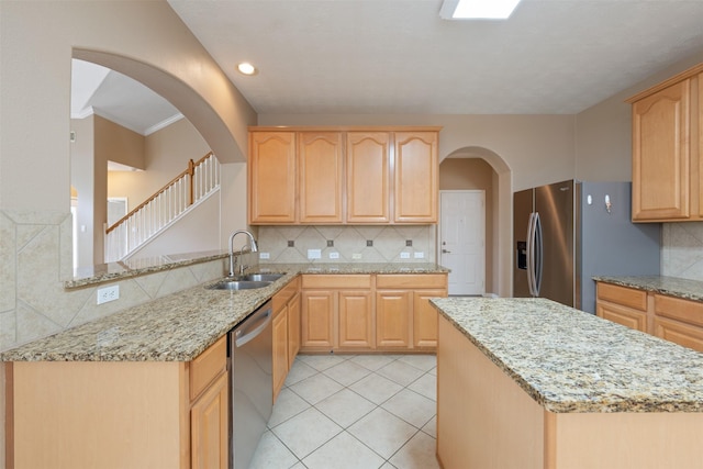 kitchen featuring light brown cabinets, backsplash, sink, appliances with stainless steel finishes, and kitchen peninsula