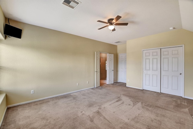 unfurnished bedroom with ceiling fan, light colored carpet, and lofted ceiling