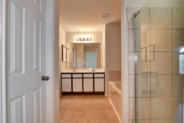 bathroom with tile patterned flooring, vanity, a textured ceiling, and plus walk in shower