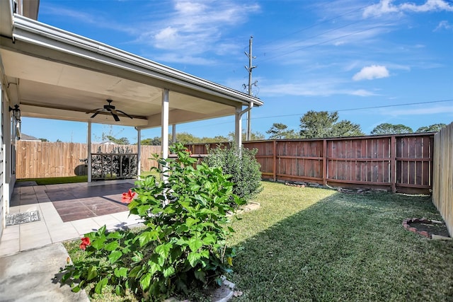 view of yard with ceiling fan and a patio area