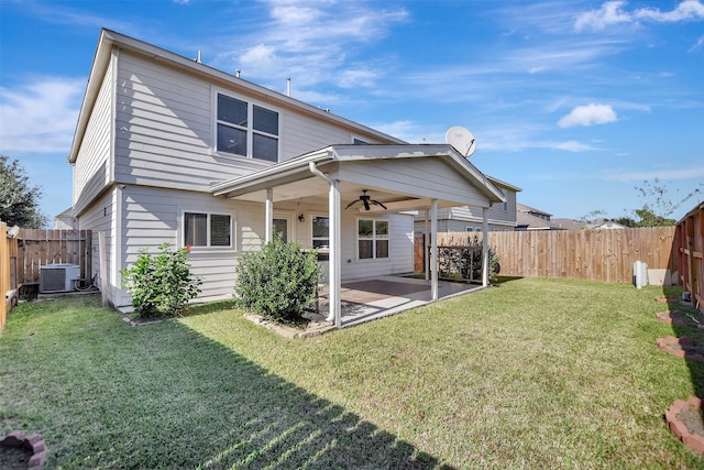 rear view of house featuring central AC unit, ceiling fan, a patio area, and a lawn