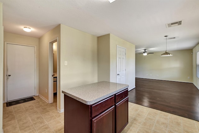 kitchen featuring light wood-type flooring, a kitchen island, hanging light fixtures, and ceiling fan