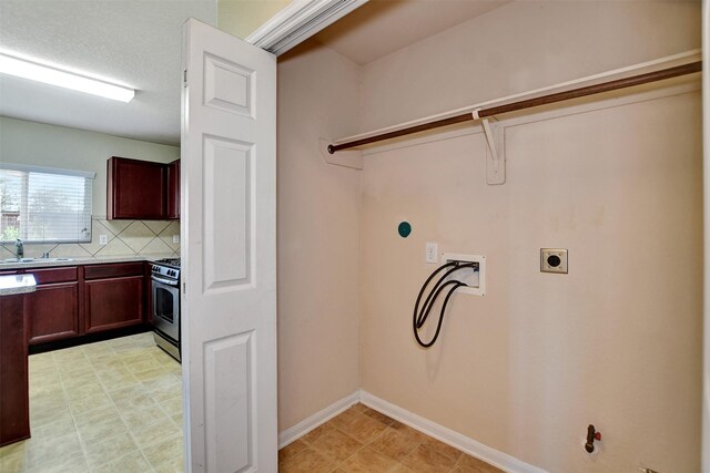 clothes washing area featuring hookup for an electric dryer, hookup for a washing machine, and sink