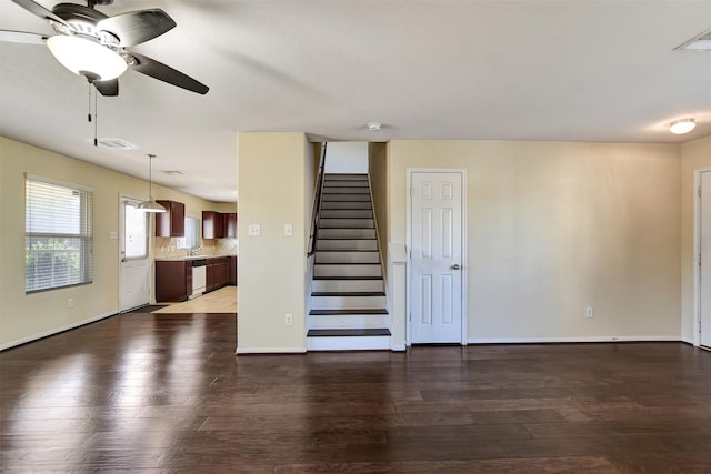 unfurnished living room featuring ceiling fan and dark hardwood / wood-style floors