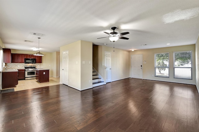 unfurnished living room with hardwood / wood-style flooring, ceiling fan, sink, and a textured ceiling