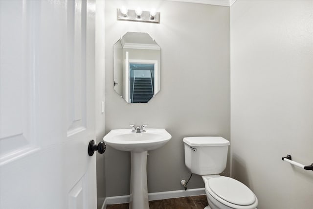 bathroom with crown molding, sink, hardwood / wood-style flooring, and toilet