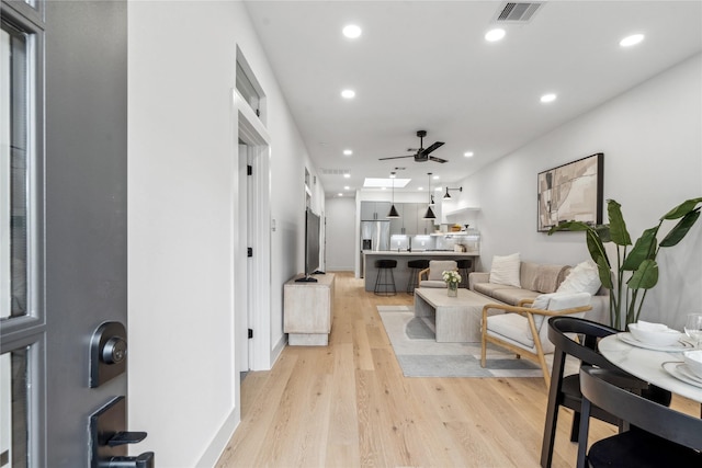 living room featuring light hardwood / wood-style flooring and ceiling fan