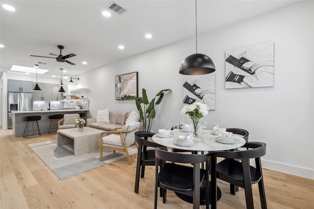 dining space featuring ceiling fan and light wood-type flooring