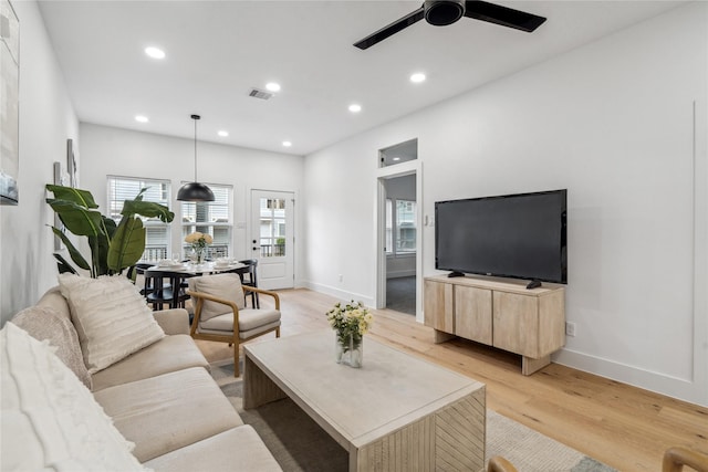 living room with ceiling fan and light wood-type flooring