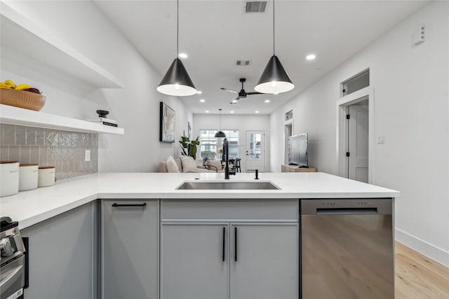 kitchen featuring gray cabinetry, sink, tasteful backsplash, decorative light fixtures, and stainless steel appliances