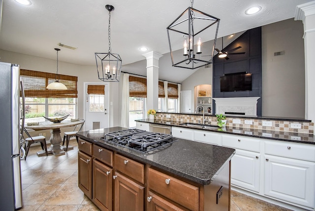 kitchen featuring white cabinetry, sink, a center island, decorative light fixtures, and appliances with stainless steel finishes