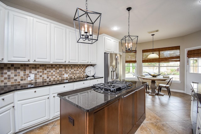 kitchen featuring a wealth of natural light, hanging light fixtures, white cabinets, and stainless steel appliances