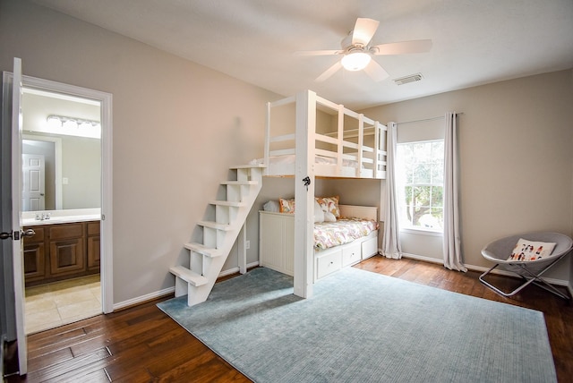 unfurnished bedroom featuring ceiling fan, sink, wood-type flooring, and ensuite bathroom