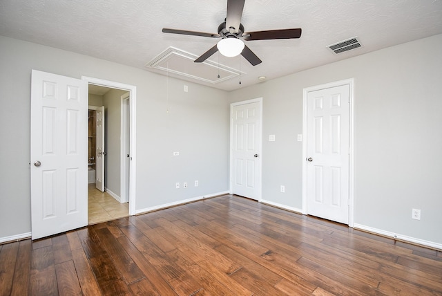 unfurnished bedroom featuring hardwood / wood-style floors, ceiling fan, and a textured ceiling