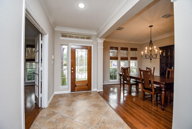 entryway with crown molding, an inviting chandelier, and light wood-type flooring