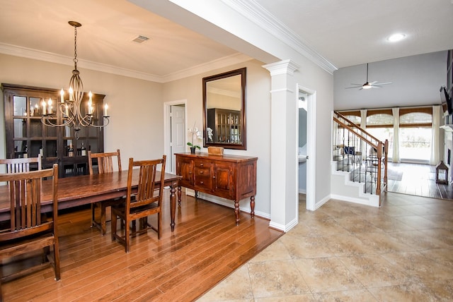 dining space with ornate columns, ornamental molding, ceiling fan with notable chandelier, and hardwood / wood-style flooring