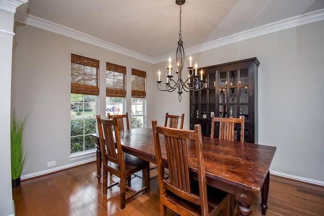 dining space with dark hardwood / wood-style flooring, ornamental molding, and a chandelier