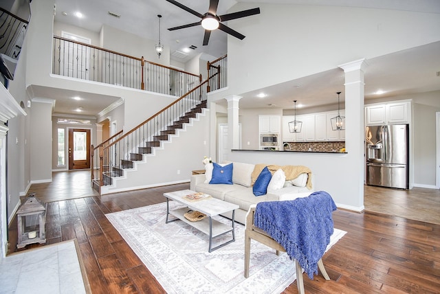 living room featuring ceiling fan, high vaulted ceiling, dark hardwood / wood-style floors, and ornamental molding