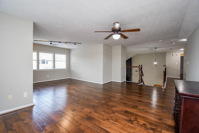 unfurnished living room featuring vaulted ceiling, ceiling fan, a textured ceiling, and dark hardwood / wood-style floors