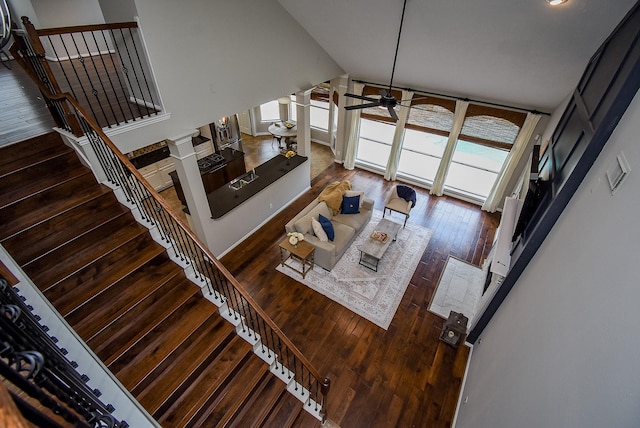 living room featuring ceiling fan, high vaulted ceiling, and wood-type flooring