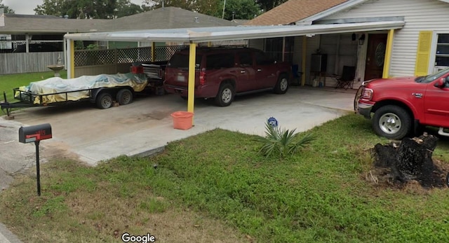 view of parking / parking lot featuring a yard and a carport