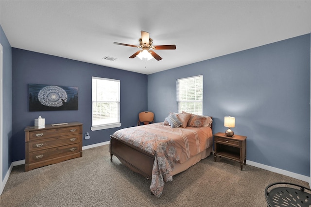 bedroom featuring multiple windows, ceiling fan, and dark carpet