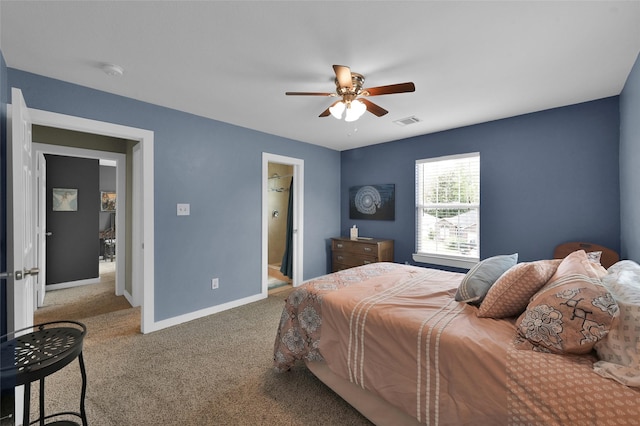 carpeted bedroom with ensuite bathroom, a spacious closet, and ceiling fan