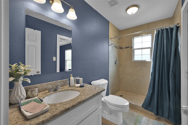 bathroom with curtained shower, tile patterned flooring, vanity, and toilet