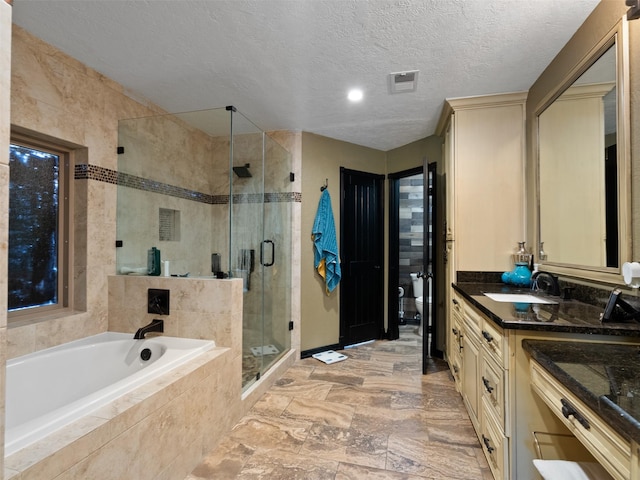 full bathroom featuring vanity, toilet, a textured ceiling, and independent shower and bath