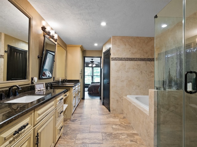 bathroom featuring separate shower and tub, vanity, and a textured ceiling