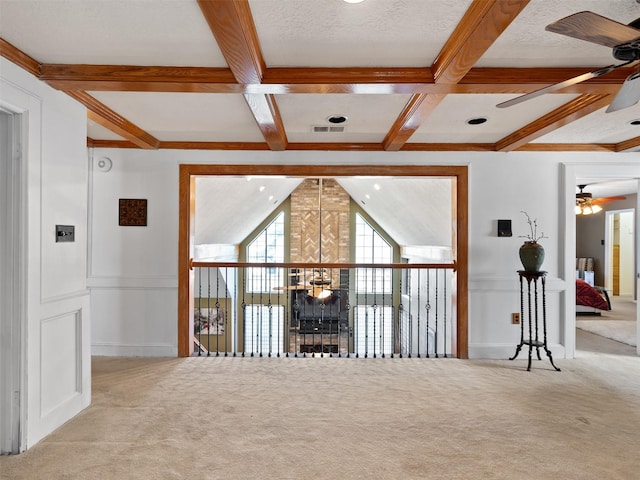 carpeted spare room featuring ceiling fan, coffered ceiling, beamed ceiling, and a textured ceiling