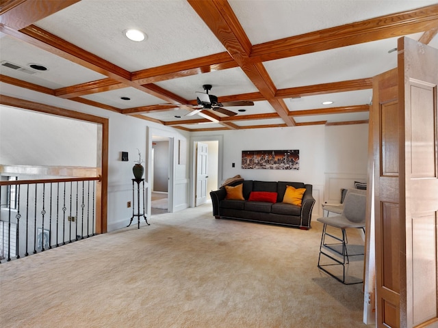 living room with ceiling fan, beamed ceiling, light colored carpet, and coffered ceiling