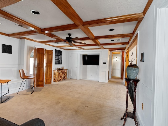 living room featuring ceiling fan, beam ceiling, light colored carpet, and coffered ceiling