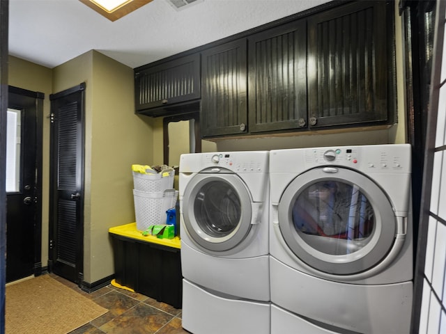 laundry area featuring separate washer and dryer and cabinets