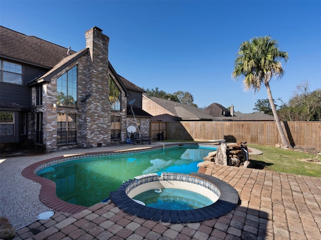 view of swimming pool with an in ground hot tub