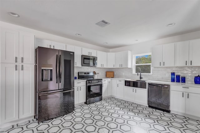 kitchen with white cabinets, backsplash, and stainless steel appliances