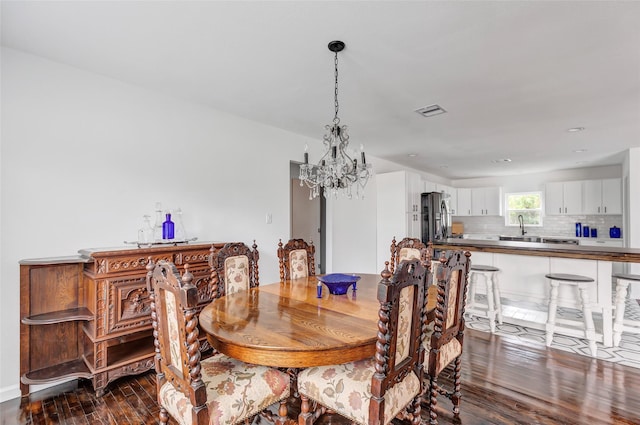 dining room with dark hardwood / wood-style flooring, a notable chandelier, and sink