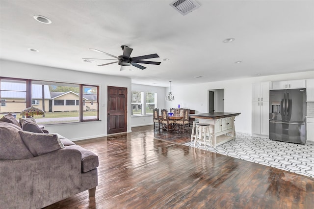 living room featuring hardwood / wood-style flooring and ceiling fan with notable chandelier