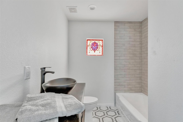 bathroom with tile patterned flooring, toilet, a tub, and sink