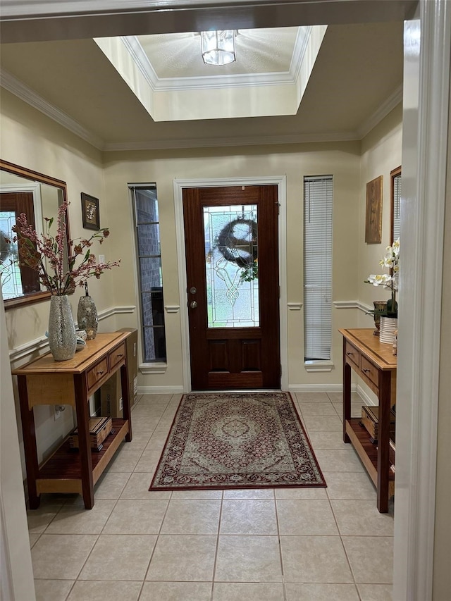 tiled foyer entrance featuring a tray ceiling and crown molding