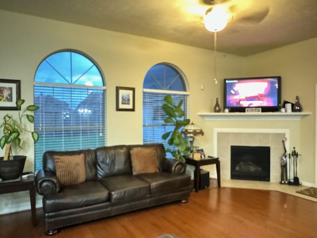 living room featuring a fireplace, hardwood / wood-style flooring, and ceiling fan