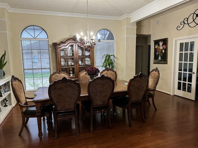 dining room with dark hardwood / wood-style flooring, an inviting chandelier, and ornamental molding