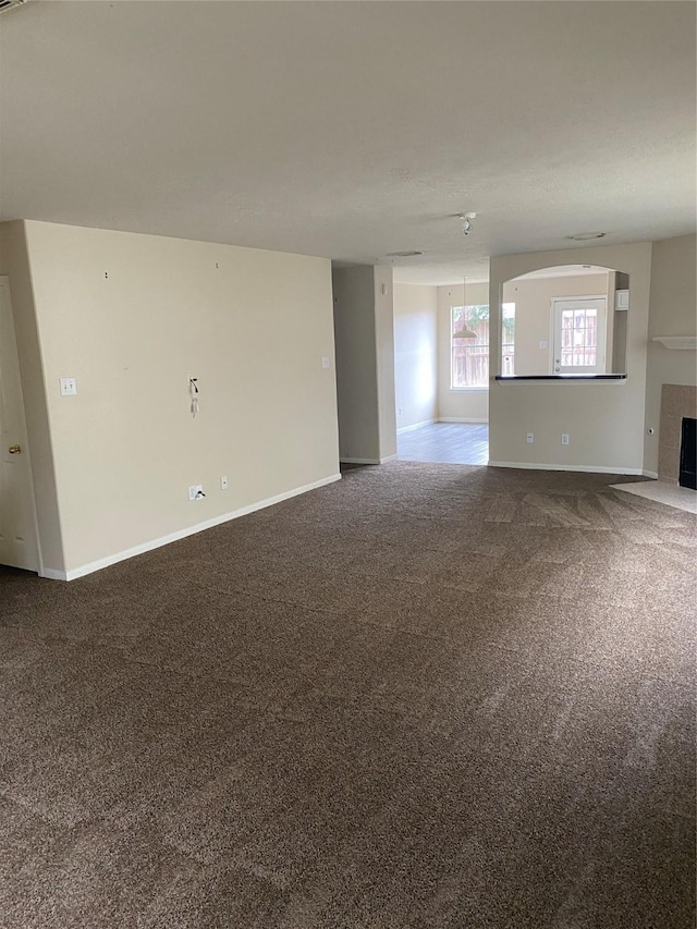 unfurnished living room featuring carpet floors and a tile fireplace