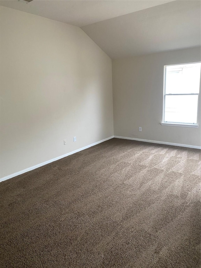 unfurnished room featuring carpet floors and vaulted ceiling